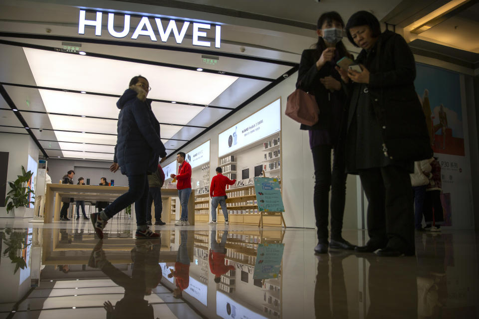 In this Nov. 20, 2019, photo, people stand outside of a Huawei store at a shopping mall in Beijing. The founder of Huawei says the Chinese tech giant is moving its U.S. research center to Canada due to American restrictions on its activities. (AP Photo/Mark Schiefelbein)