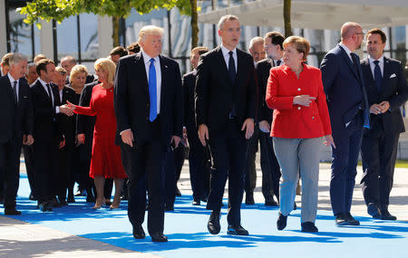 (L-R) U.S. President Donald Trump, NATO Secretary General Jens Stoltenberg and German Chancellor Angela Merkel gather with NATO member leaders to pose for a family picture before the start of their summit in Brussels, Belgium, May 25, 2017.REUTERS/Jonathan Ernst