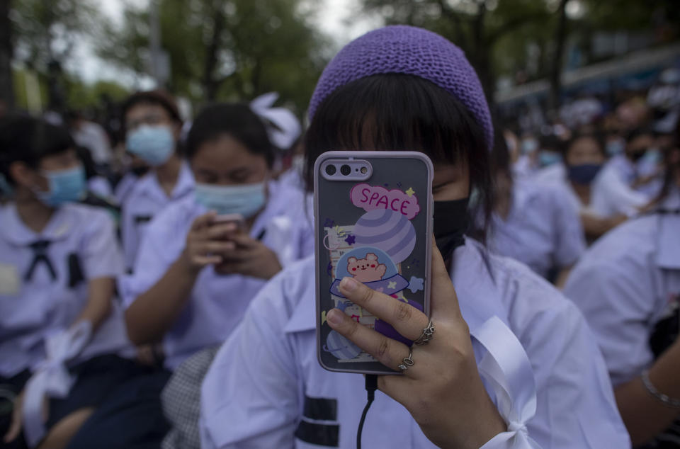 A High school student take pictures as she attends a protest rally in Bangkok, Thailand, Saturday, Sept. 5, 2020. The student's demonstration comes at a time of mass anti-government protests led predominantly by university students, putting added strain on the under-pressure administration of Prime Minister Prayuth Chan-ocha. (AP Photo/Gemunu Amarasinghe)