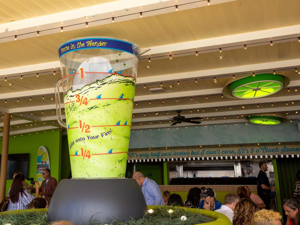 A statue of a blender with lime-shaped lights on the ceiling.