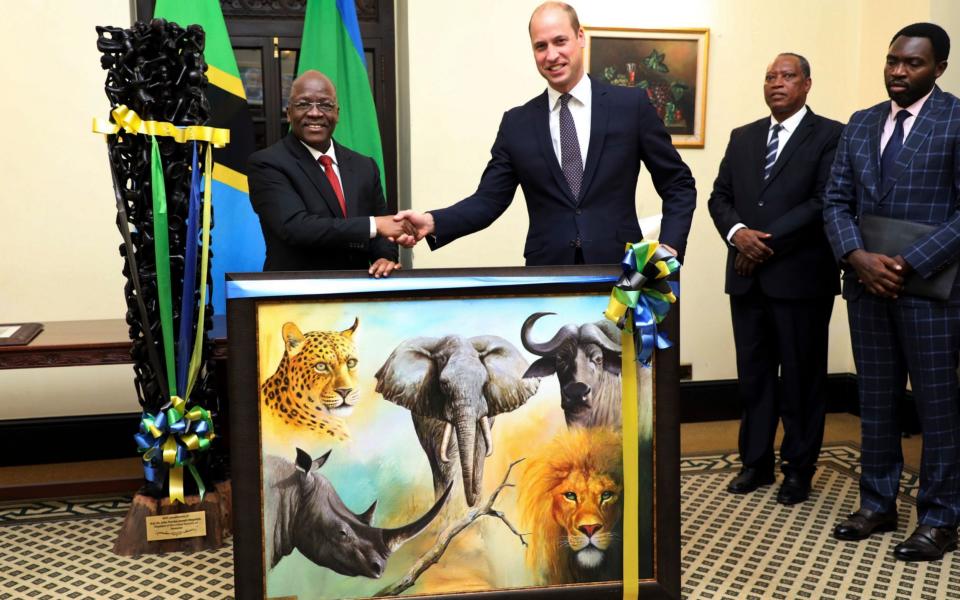 Magufuli with the Duke of Cambridge. He gifted the duke a painting showing the wildlife of Tanzania during a royal visit in 2018 - AP