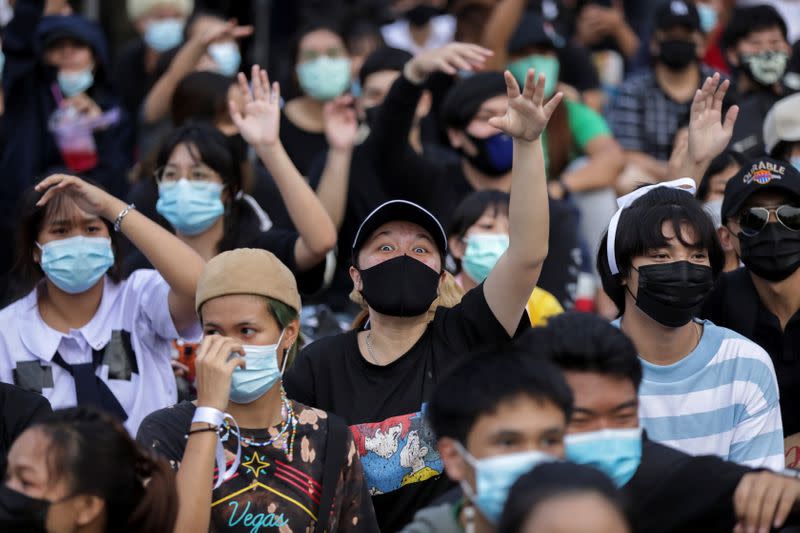 Pro-democracy protesters use hand signals during an anti-government protest in Bangkok