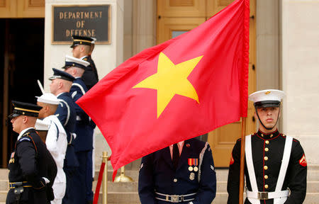 A Vietnam flag flies over the face of an honor guardsman as U.S. Defense Secretary Jim Mattis hosts Vietnamese Defense Minister Gen. Ngo Xuan Lich at the Pentagon in Arlington, Virginia, U.S., August 8, 2017. REUTERS/Kevin Lamarque