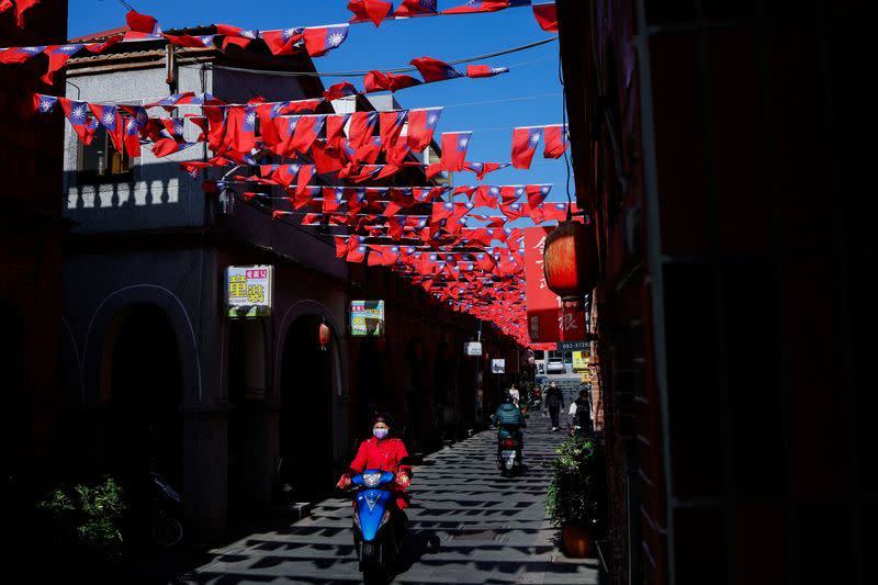 FILE PHOTO: People drive pass a street decorated with Taiwanese flags in Kinmen
