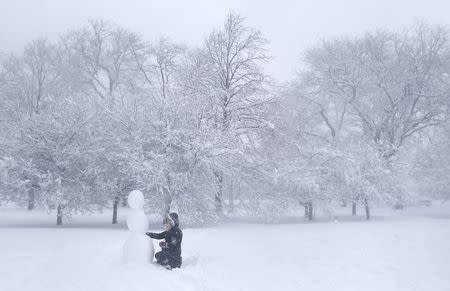 MacKenzie Perkins builds a snowman in a park during blizzard conditions in Chicago, Illinois February 1, 2015. REUTERS/Jim Young