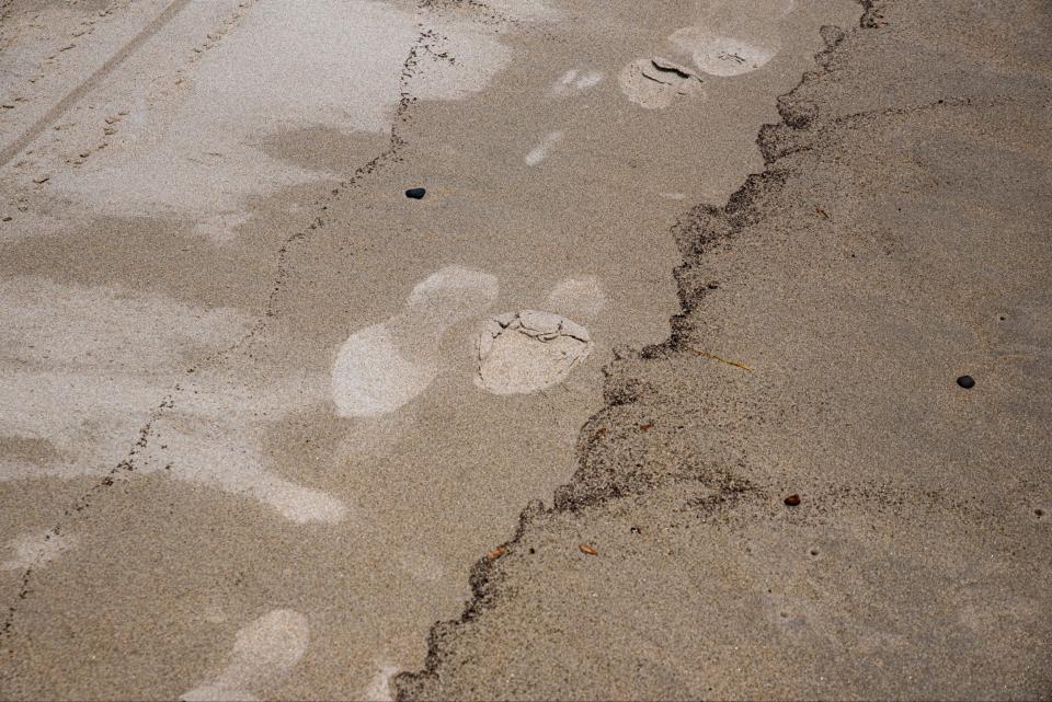 Darker deposits appear on a sandy beach in Wells, Maine, on Tuesday, June 8, 2021, as people began reporting significant discoloration to their feet after leaving beaches up and down the York County coastline. State officials said they are looking into the cause.