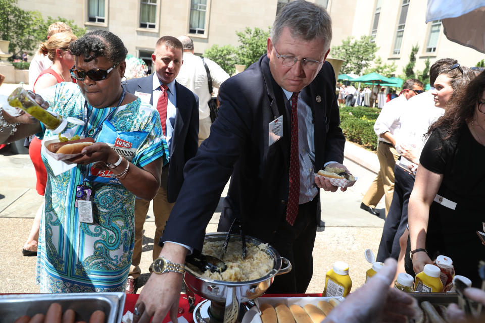 Rep. Frank Lucas (R-Okla.) prepares a hot dog during the American Meat Institute's annual Hot Dog Lunch in the Rayburn Office Building courtyard on July 19, 2017.&nbsp;