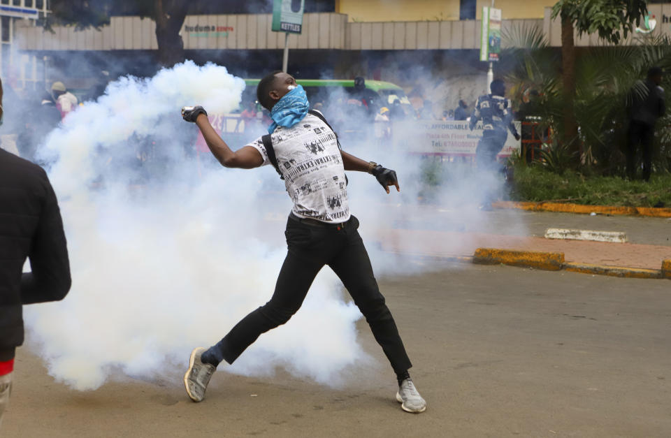 A protesters throws back a teargas canister at police officers during a protest over proposed tax hikes in a finance bill that is due to be tabled in parliament in Nairobi, Kenya, Thursday, June 20, 2024. (AP Photo/ Andrew Kasuku)