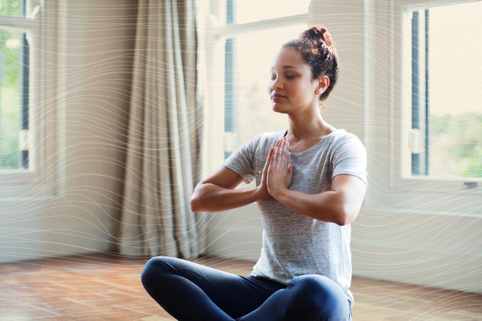 Young woman meditating with hands joined at home