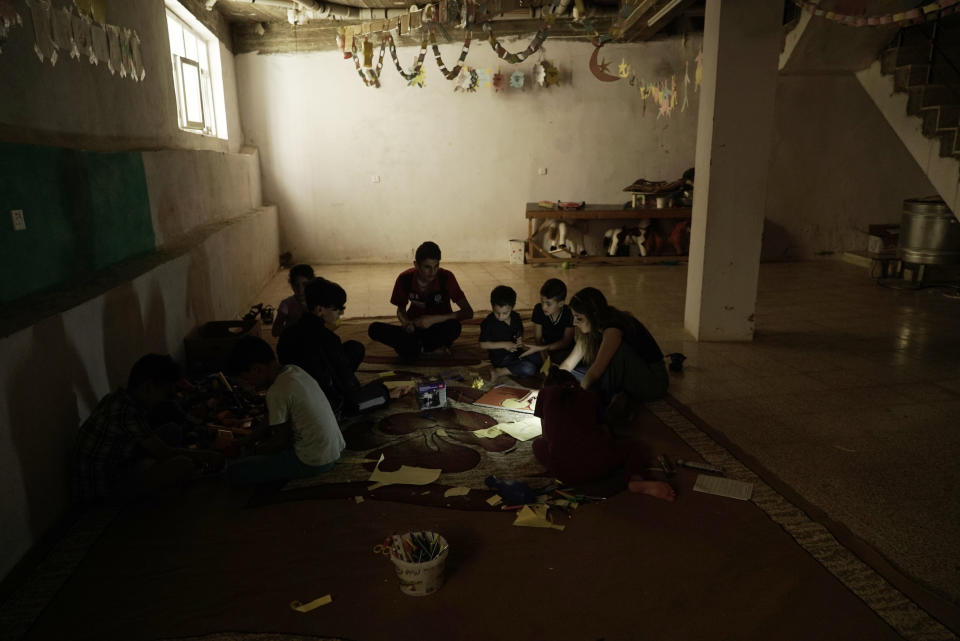 In this Aug. 22, 2018 photo, Yazidi children work on arts and crafts in the basement of an orphanage in Sheikhan, Iraq. The Yazidi community is wrestling with integrating thousands of children affected by the war. Those whose parents are missing or dead are usually taken in by extended family, but if relatives can't afford it, they end up in orphanages. Children snatched by IS and raised as Muslims have to be retaught the Yazidi faith. Boys forced to become child soldiers have to be led back from IS's virulently violent training. (AP Photo/Maya Alleruzzo)