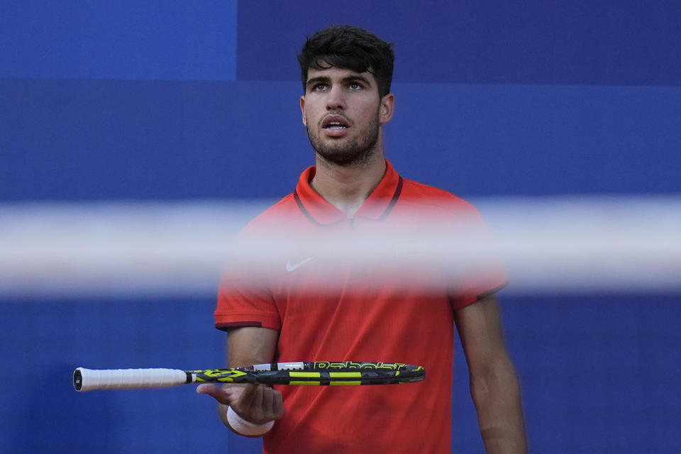 Carlos Alcaraz of Spain spins his racquet as he waits for the second set against Tallon Griekspoor of the Netherlands during their men's singles second round match, at the 2024 Summer Olympics, Monday, July 29, 2024, at the Roland Garros stadium in Paris, France. (AP Photo/Andy Wong)