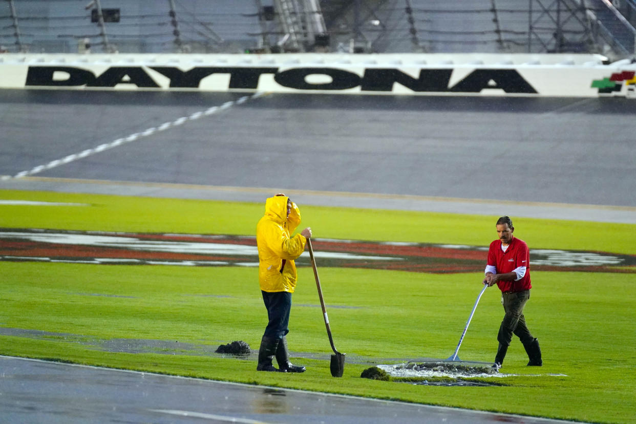 Aug 27, 2022; Daytona Beach, Florida, USA; Grounds crews work to mediate pooling water in the infield trioval during a rain delay for the Coke Zero Sugar 400 at Daytona International Speedway. Mandatory Credit: John David Mercer-USA TODAY Sports