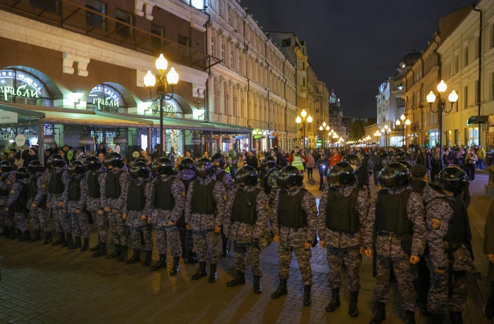 Russian police officers stand guard against protesters