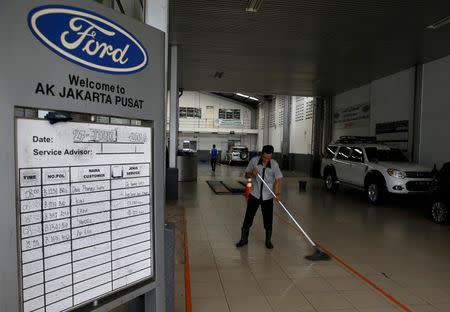 A worker cleans the floor of the car repair shop at the Central Jakarta Ford Dealer in Jakarta, Indonesia, June 27, 2016. REUTERS/Beawiharta