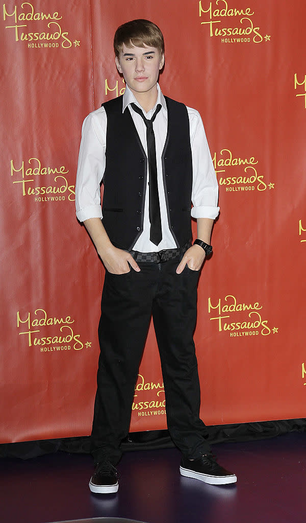 Wax figure resembling Justin Bieber in a black vest, white shirt, and black pants at Madame Tussauds