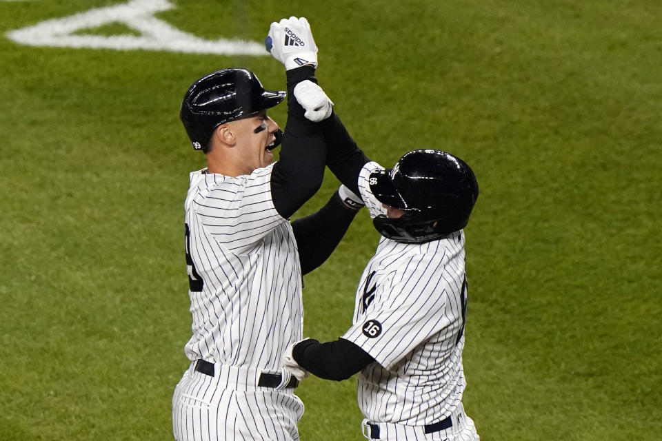 New York Yankees Aaron Judge, left, celebrates with Yankees Kyle Higashioka after Higashioka scored on Judge's eight-inning, three-run home run in a baseball game against the Baltimore Orioles, Tuesday, April 6, 2021, at Yankee Stadium in New York. (AP Photo/Kathy Willens)