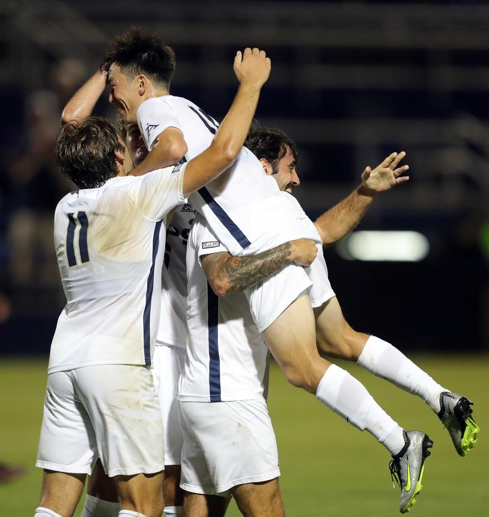 Akron midfielder Gyuwon Chong, top, is lifted up by teammates after his second-half goal against Niagara Thursday in Akron.