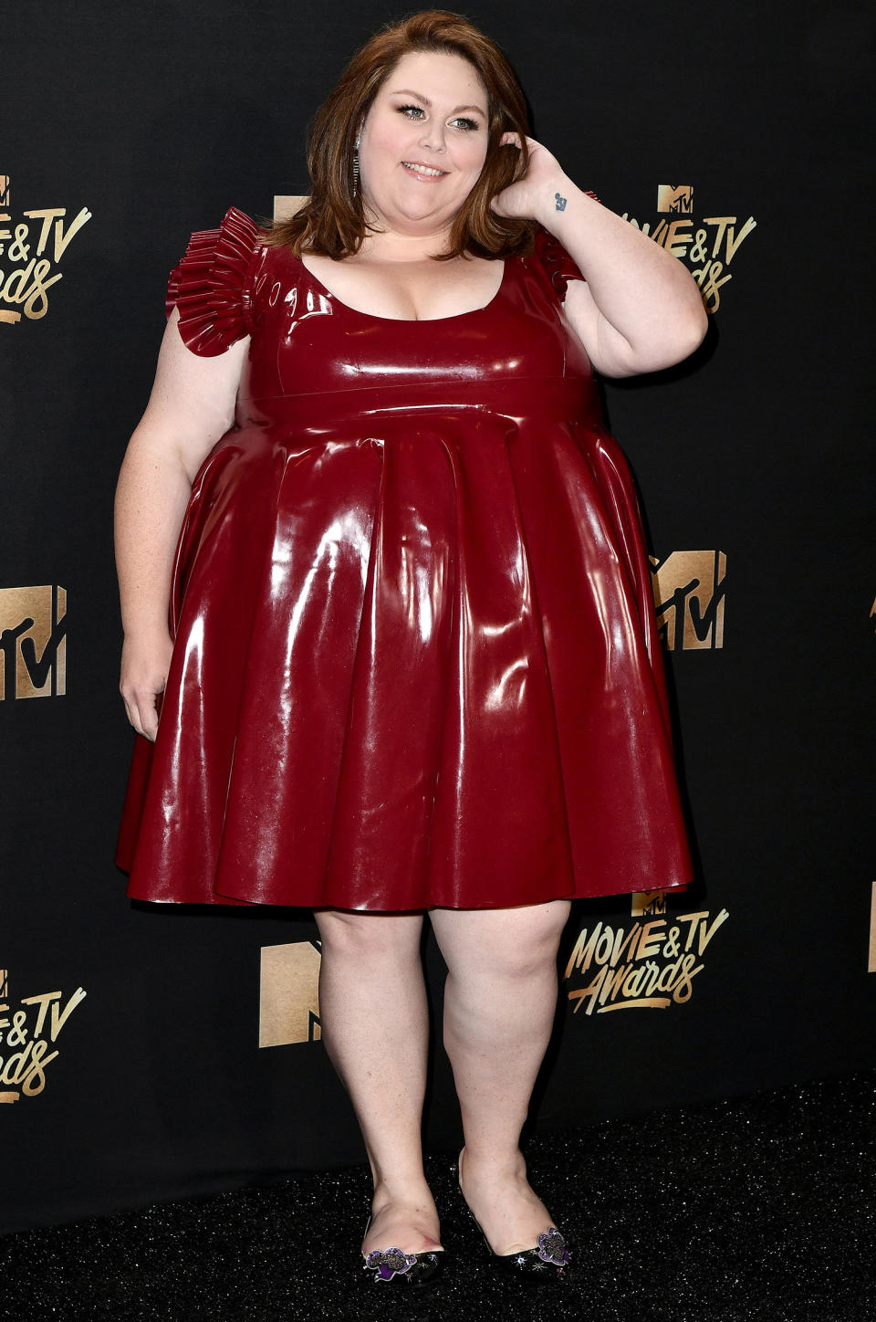 Chrissy Metz made her debut at the MTV Movie & TV Awards in an oxblood leather dress with ruffled cap sleeves and a pleated skirt. (Photo: Getty Images)