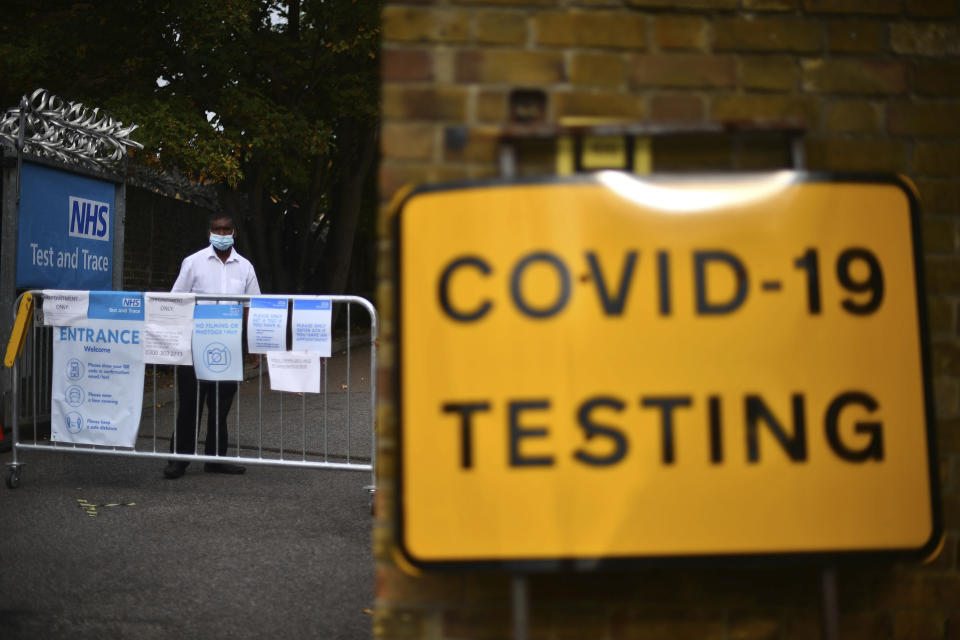 A member of staff stands at the entrance to a coronavirus testing centre in Newham, east London, Wednesday, Sept. 16, 2020. The British government plans to ration coronavirus testing, giving priority to health workers and care home staff after widespread reports that people throughout the country were unable to schedule tests. Prime Minister Boris Johnson on Wednesday will face questions about his handling of the COVID-19 pandemic in the House of Commons and before a key committee amid the outcry over the shortage of testing. (Victoria Jones/PA via AP)