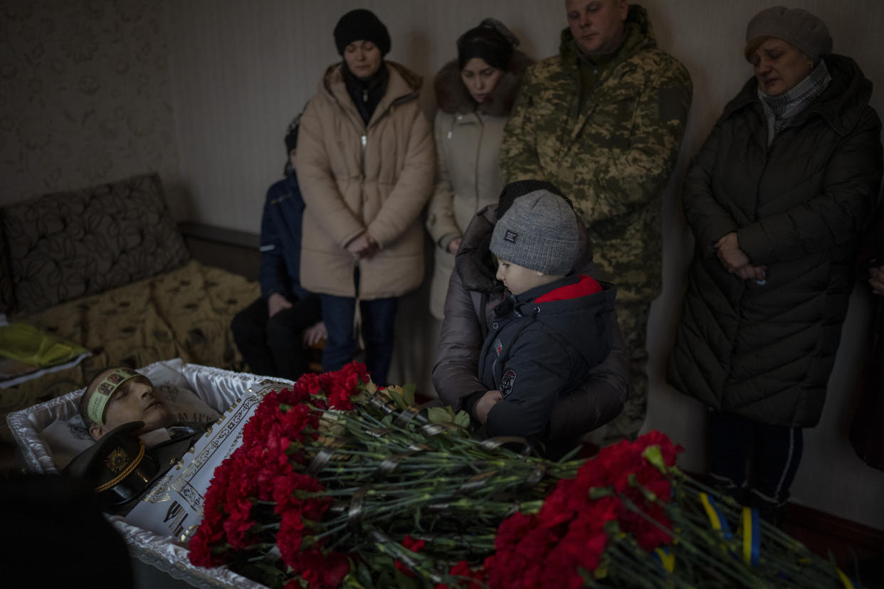 Tymofii, 5, sits next to the body of his father Kostiantyn, 35, during his funeral in Borova, near Kyiv, Ukraine, Saturday, Feb. 18, 2023. Kostiantyn Kostiuk, a civilian who was a volunteer in the armed forces of Ukraine, was wounded during a battle against Russians on Jan. 23rd near Bakhmut and finally died on Feb. 10th in a hospital. (AP Photo/Emilio Morenatti)