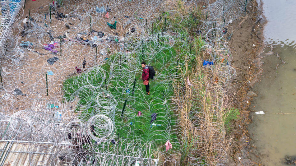 In an aerial view, an immigrant faces coils of razor wire after crossing the Rio Grande from Mexico on March 17, 2024 in Eagle Pass, Texas. / Credit: John Moore/Getty Images