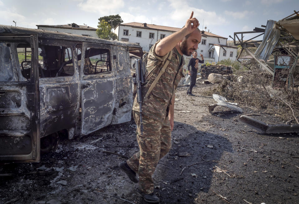 Gevorg, a doctor of a local hospital damaged by shelling from Azerbaijan's artillery, points in direction of the noise of Azerbaijan's military jet bombing the town of Martakert, during a military conflict, the separatist region of Nagorno-Karabakh, Thursday, Oct. 15, 2020. The conflict between Armenia and Azerbaijan is escalating, with both sides exchanging accusations and claims of attacks over the separatist territory of Nagorno-Karabakh.(AP Photo)