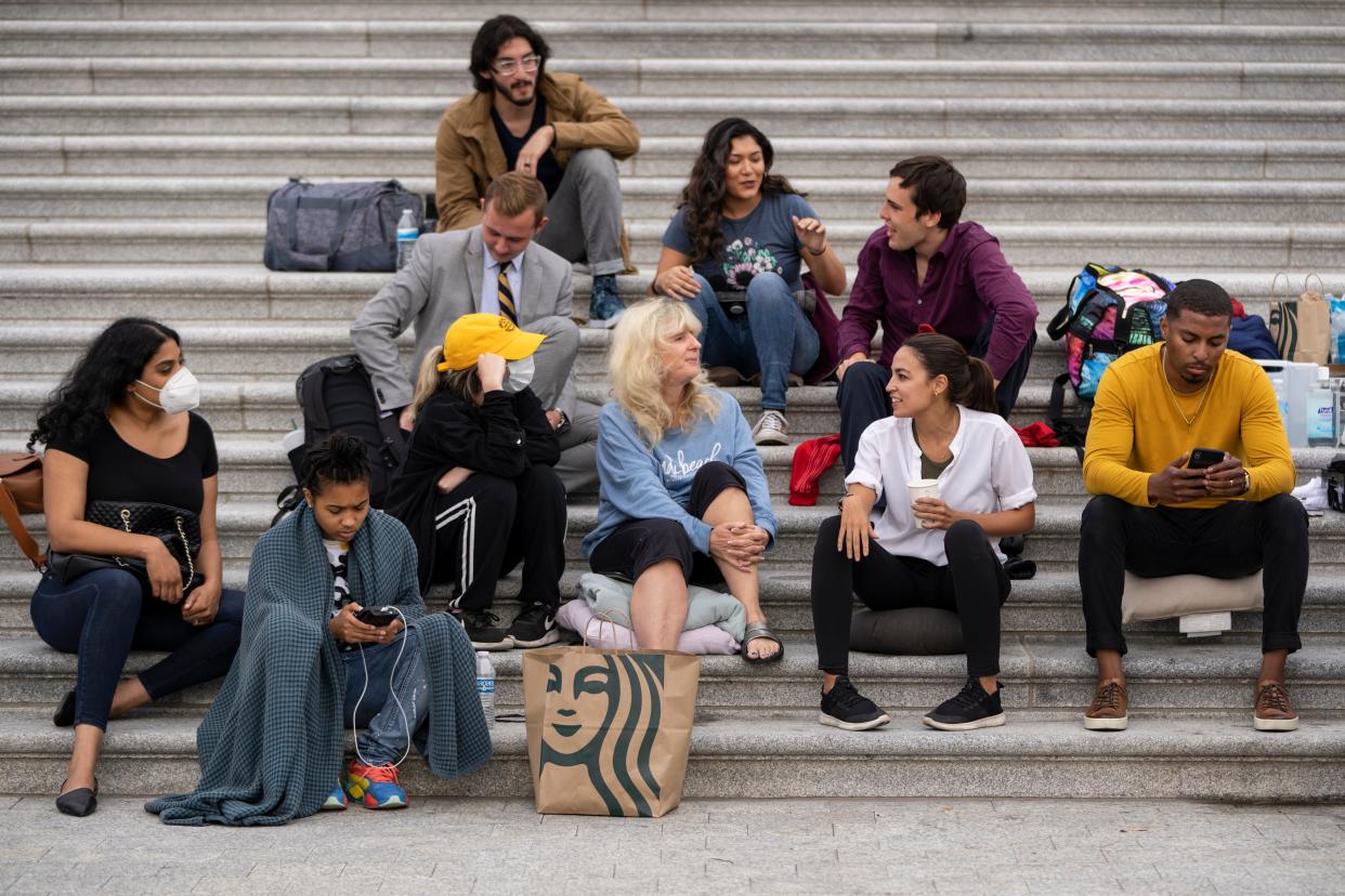 Congresswoman Alexandria Ocasio-Cortez sits with housing activists on the steps of the US Capitol on 3 August, 2021, in protest of the federal eviction moratorium expiring last week. (Getty Images)