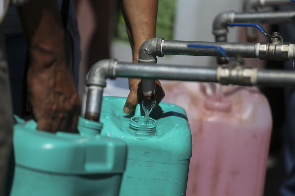 Vecinos llenan garrafas de plástico con agua en un punto de suministro público en Monterrey, México, el 20 de junio de 2022. Las autoridades locales comenzaron a restringir el suministro de agua en marzo debido a la combinación de una intensa sequía, una mala planificación y un uso excesivo que ha secado las tres presas que abastecen a la ciudad, y miles de viviendas no reciben agua desde hace semanas. (AP Foto)