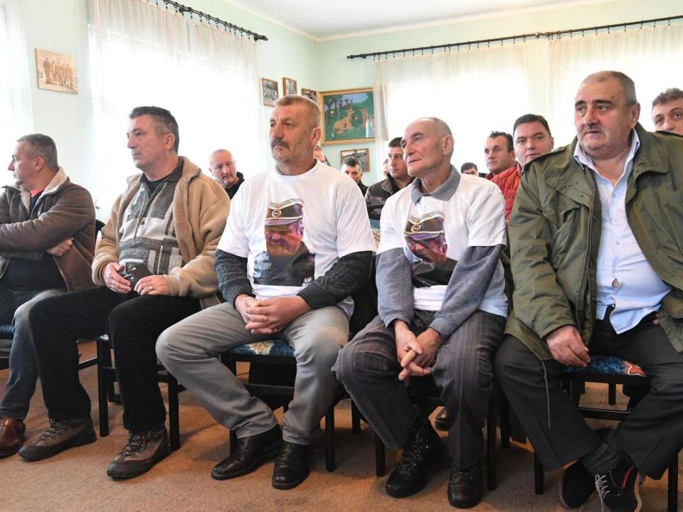 Bosnian Serbs, two wearing T-shirts with Mladic’s portrait, watch a live TV broadcast of the ruling (Getty)