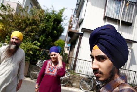 Gursewak Singh (R) and his parents stand in front of their house as they prepare to pose for a photographer during an interview with Reuters, in Matsudo, Japan, September 25, 2016. REUTERS/Kim Kyung-Hoon