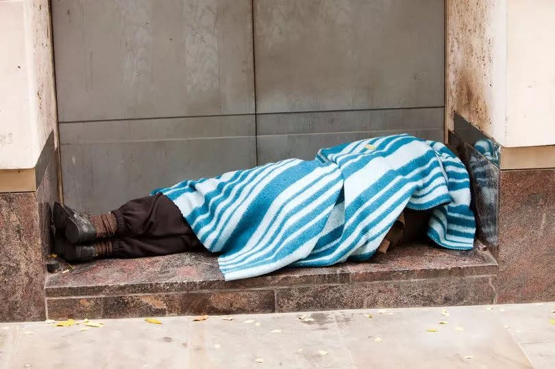 A homeless person sleeping rough in a doorway in London, UK.