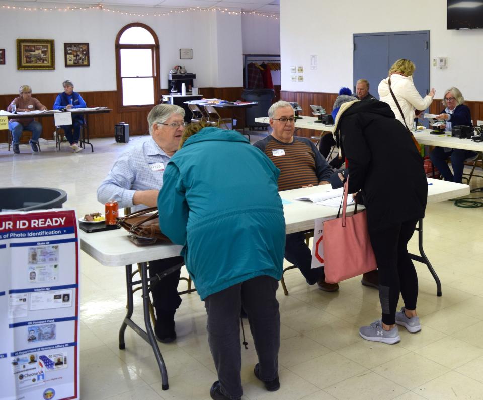 Poll workers greet voters upon entering the Holmes County Catholic Center in Millersburg on Tuesday.