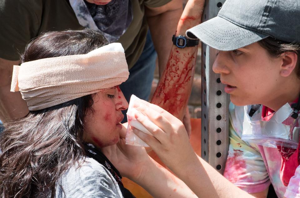 A woman receives first aid after a car plowed into a crowd of anti-racist demonstrators, killing Heather Heyer, a 32-year-old paralegal, in Charlottesville, Virginia, on Aug. 12, 2017.