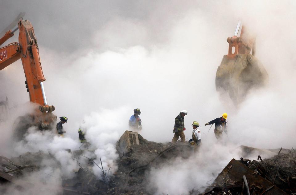 Firefighters make their way through the ruins of the World Trade Center amid clouds of dust and smoke Oct. 11, 2001, at Ground Zero in New York.