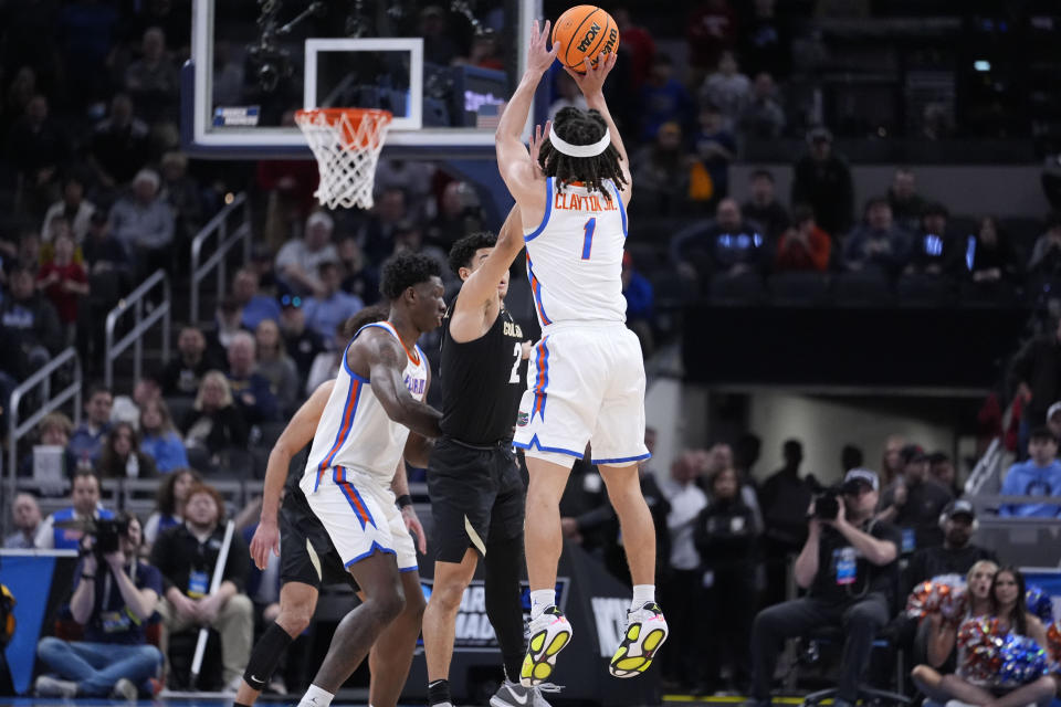 Florida guard Walter Clayton Jr. (1) shoots a three-point basket over Colorado guard KJ Simpson (2) in the second half of a first-round college basketball game in the NCAA Tournament, Friday, March 22, 2024, in Indianapolis. Colorado won 102-100. (AP Photo/Michael Conroy)