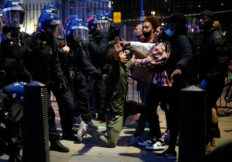 A protestor was seen kneeling in front of riot police in the middle of the fray as he appealed for calm from his fellow protesters.(AFP via Getty Images)