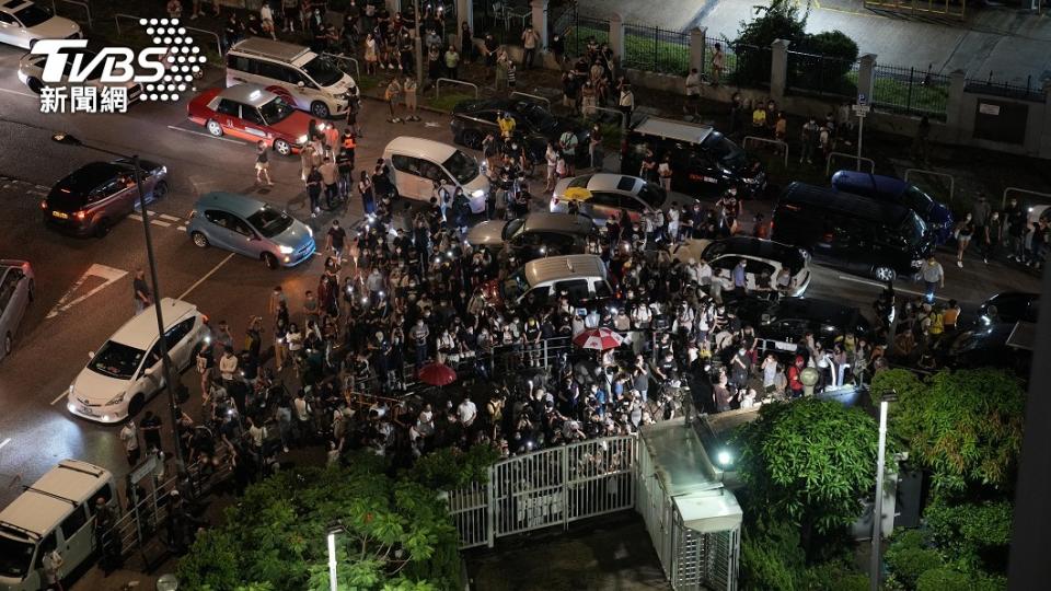 許多讀者冒著夜雨，來到香港蘋果日報總部門外致意。（圖／達志影像美聯社）