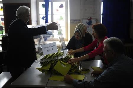 An election official empties a ballot box at a polling station during the parliamentary election in Istanbul, Turkey, June 7, 2015. REUTERS/Yagiz Karahan