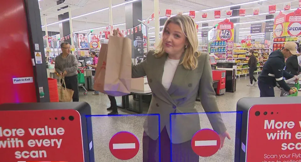 A shopper being held up at a security gate in Coles.