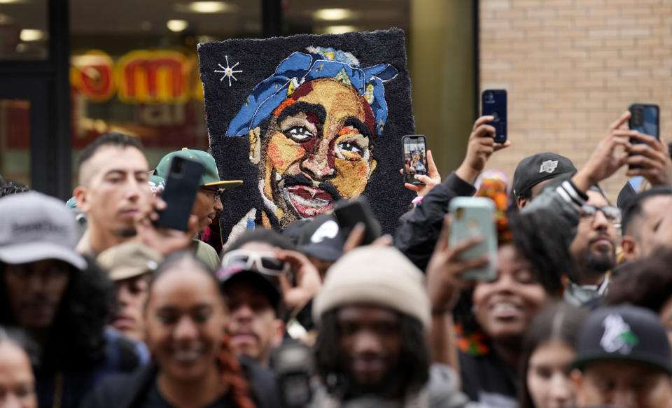 An image of the late rapper and actor Tupac Shakur appears among fans during a ceremony honoring Shakur with a star on the Hollywood Walk of Fame on Wednesday, June 7, 2023, in Los Angeles. (AP Photo/Chris Pizzello)