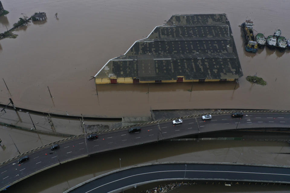 Vehicles travel along a lateral highway restored to allow the movement of humanitarian aid for those affected by floods caused by heavy rains, in Porto Alegre, Rio Grande do Sul state, Brazil, Saturday, May 11, 2024. (AP Photo/Wesley Santos)