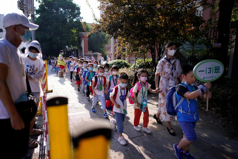 Estudiantes con mascarilla salen de una escuela primaria en Wuhan, provincia de Hubei, China