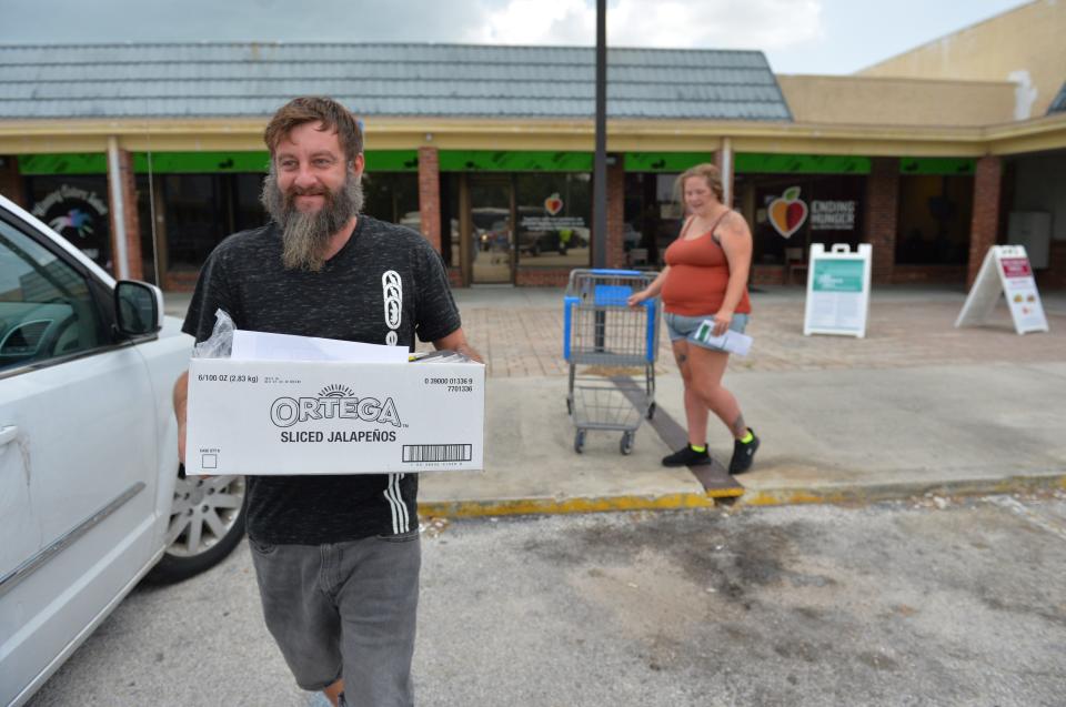 Cody Lockhart and his wife, Kerrigan Cook, receive food  for the first time from the DeSoto Food and Resource Center in Arcadia. The family, with three boys, had to reapply for SNAP benefits and was still waiting for approval so the food was a huge help. 
