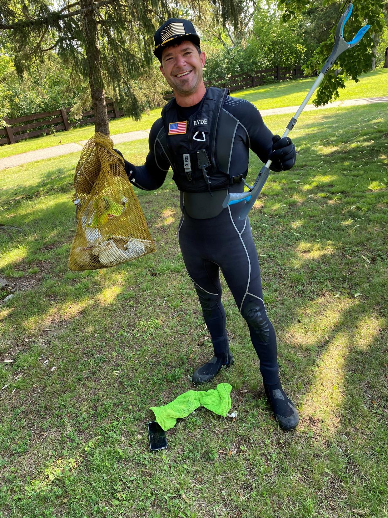 Ed Bieber of Marinette, known online as "Ed the Diver," shows some of the trash he picked up along the Wisconsin River in Wausau. He's become an internet celebrity by writing and posting about how he cleans up garbage from waterways across the Midwest.