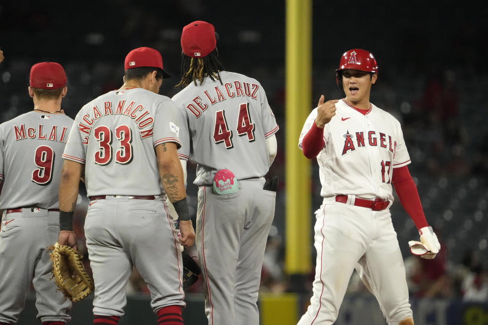 Los Angeles Angels' Shohei Ohtani, right, talks with Cincinnati Reds Matt McLain, second from left, Christian Encarnacion-Strand, second from left, and Elly De La Cruz as he stands on second during a pitching change in the fifth inning in the second baseball game of a doubleheader Wednesday, Aug. 23, 2023, in Anaheim, Calif. (AP Photo/Mark J. Terrill)