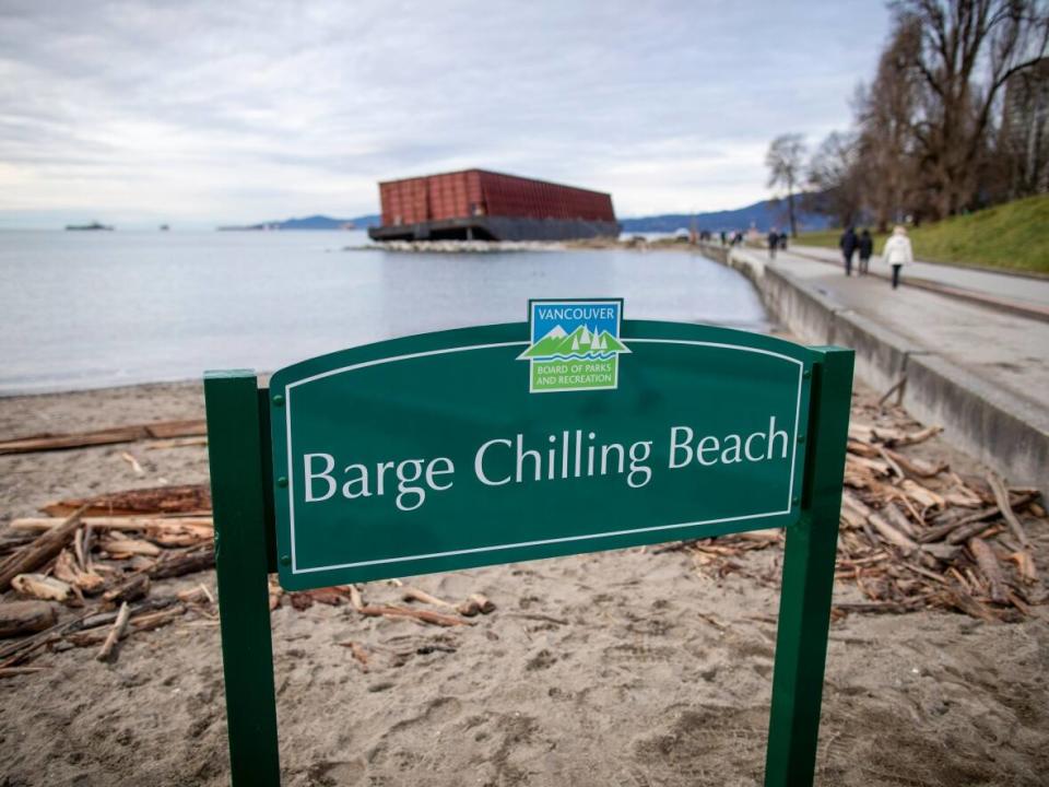 The Vancouver Park Board has installed a sign near the barge that ran aground near Sunset Beach during the storms of Nov. 15. (Ben Nelms/CBC - image credit)