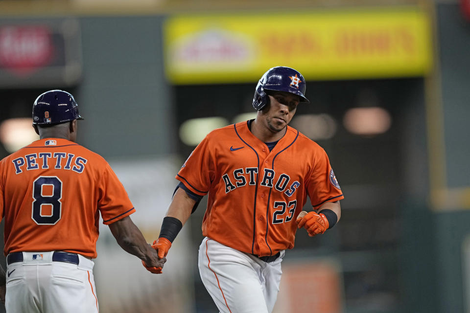 Houston Astros' Michael Brantley (23) celebrates with third base coach Gary Pettis (8) after hitting a home run against the Miami Marlins during the first inning of a baseball game Friday, June 10, 2022, in Houston. (AP Photo/David J. Phillip)