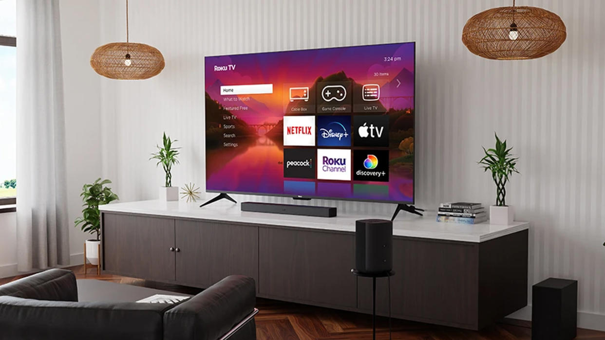  Roku Plus Series 4K QLED TV on tv stand. 