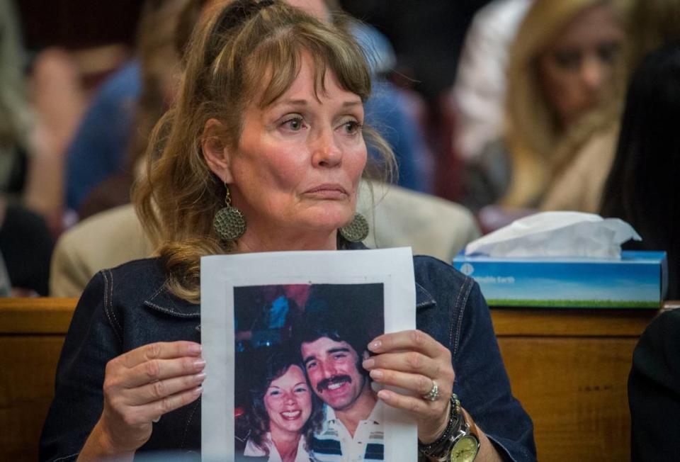 Melanie Barbeau holds a photograph of victims Cheri Domingo and Greg Sanchez during the arraignment of Joseph James DeAngelo, the suspected East Area Rapist on Friday, April 27, 2018 in Sacramento. The couple is believed to have been killed by DeAngelo in 1981 in Goleta, Calif.
