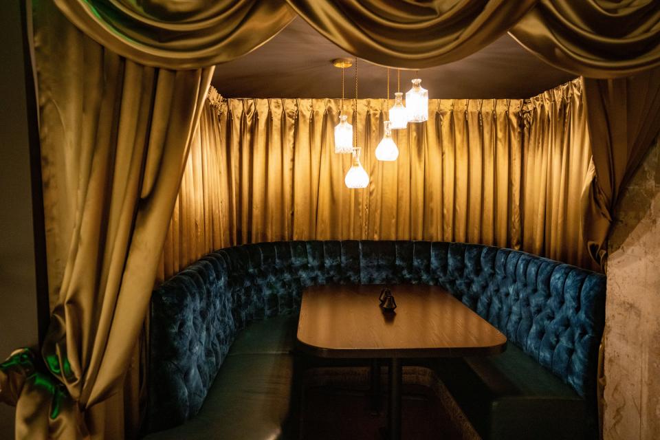 A blue velvet booth at In Confidence, the new speakeasy at the Hotel Fort Des Moines, gives off a cozy vibe.